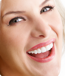 A woman with blonde hair smiling after seeing a cosmetic dentist in Horsham