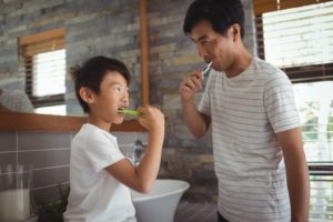 parent and child brushing their teeth together